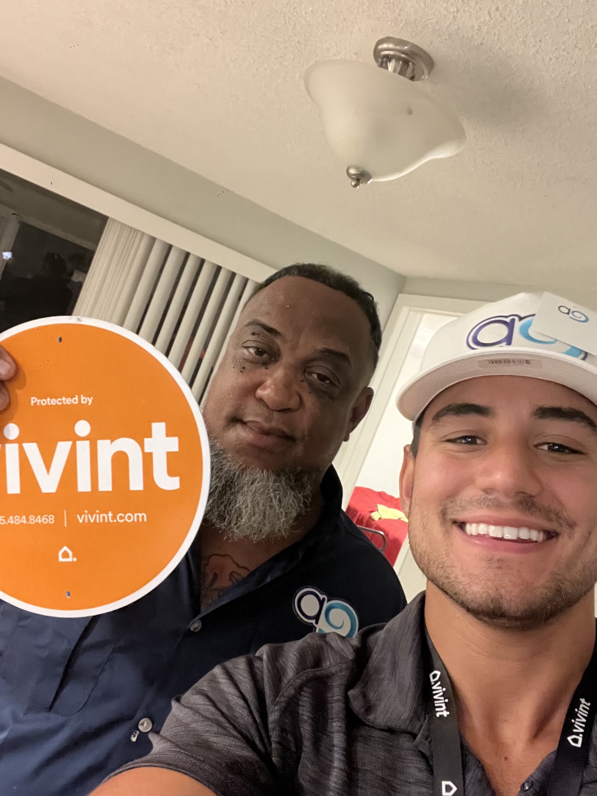 Selfie with a customer holding the Vivint sign indoors