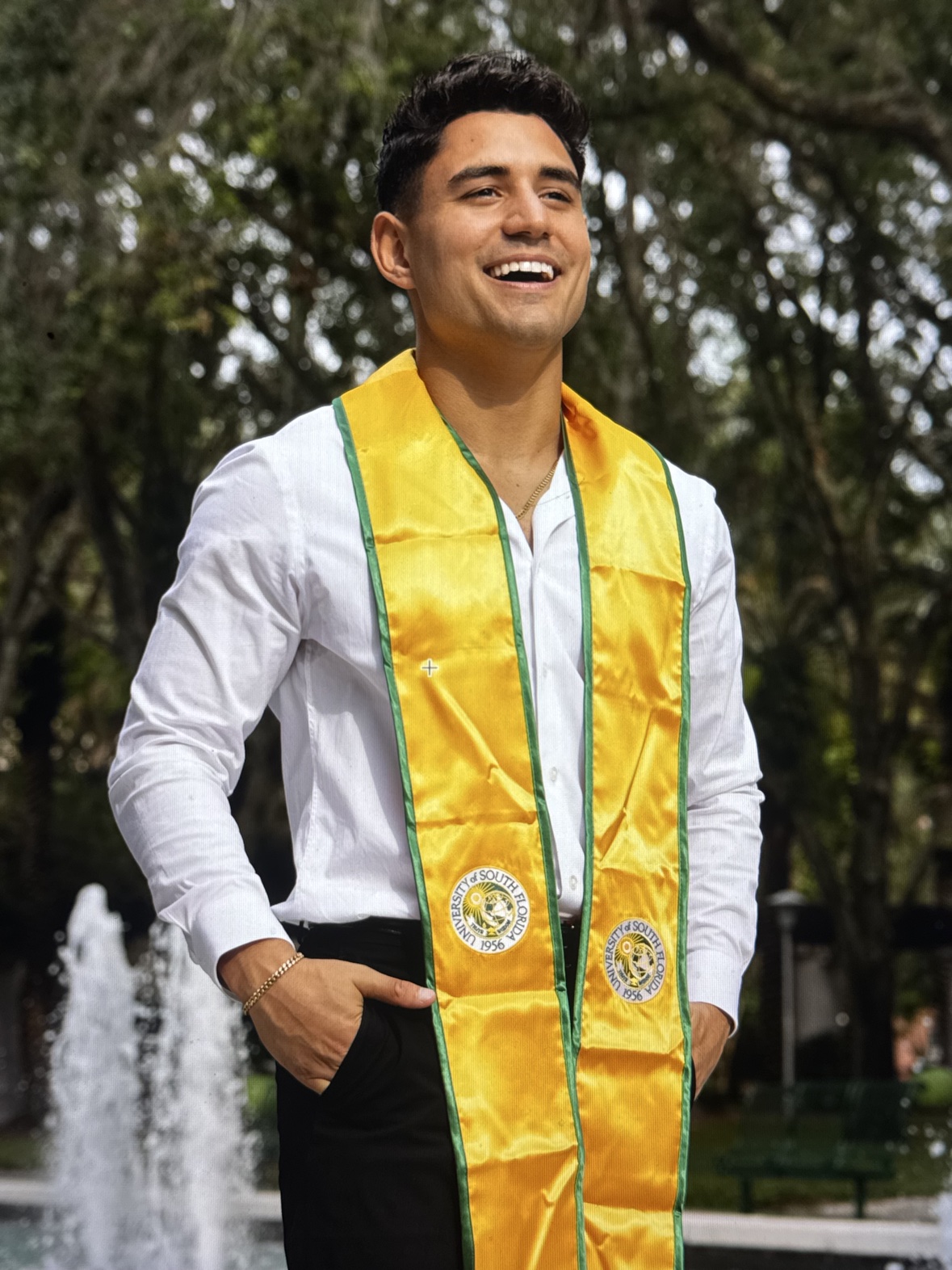 Matthew's graduation portrait in the gold University of South Florida stole by the campus fountain